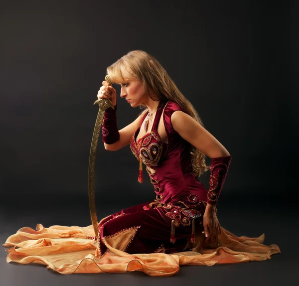 Schönheit arabische Tänzerin sitzen mit Säbel — Stockfoto