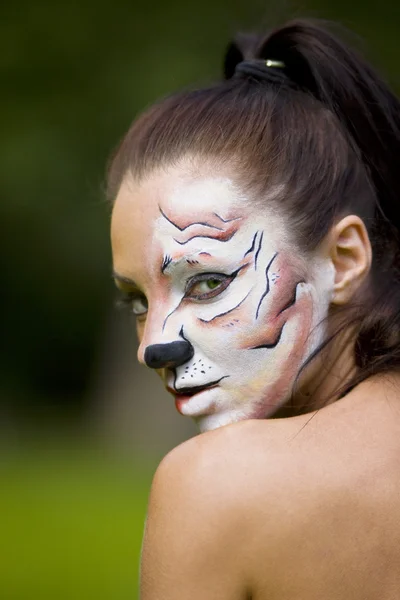 Jonge vrouw met tijgerin gezicht kunst — Stockfoto