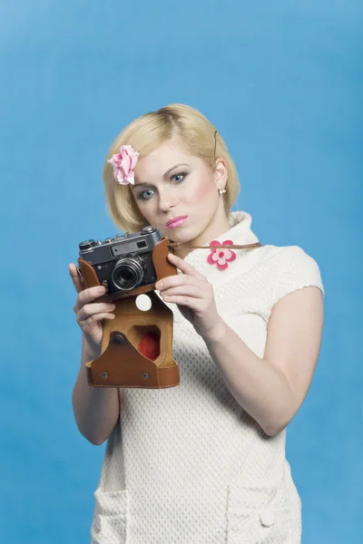Blond girl look at retro camera — Stock Photo, Image