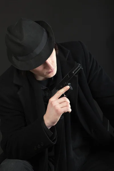 Hombre con pistola y sombrero negro — Foto de Stock