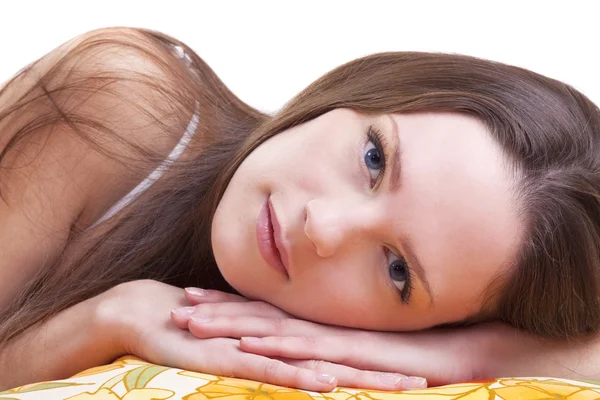 Ung kvinna låg på färg kudde och titta på dig — Stockfoto