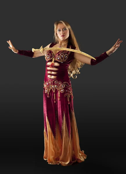 Арабианская танцовщица стоит с саблей на груди — стоковое фото