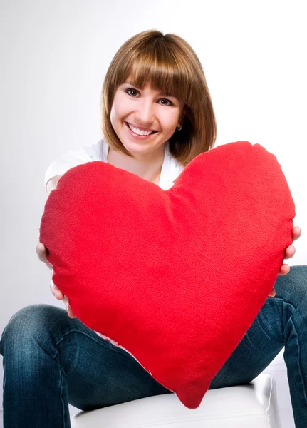 Krásná mladá brunetka s červeným srdcem — Stock fotografie