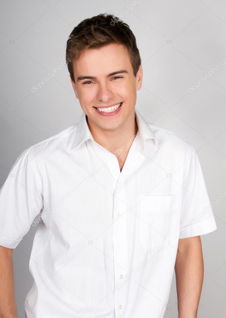 handsome young man smiles and looks into the camera
