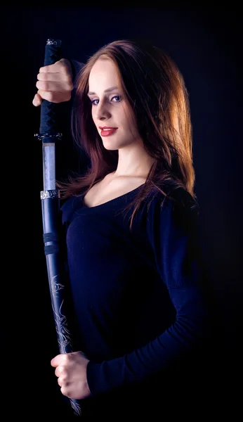 一位年轻女郎在黑色背景上的一把剑 — 图库照片