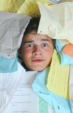 Young male student is overwhelmed by way too many homework assignments. clipart