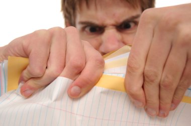 Angry young man ripping trying to papers on white background. Background is blurred intentionally. clipart