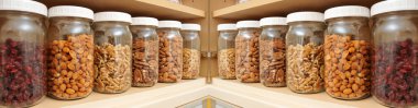 Healthy Nuts in Glass Jars sitting on a shelf. clipart