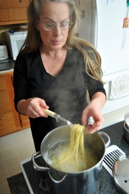 Woman cooking spaghetti noddles clipart