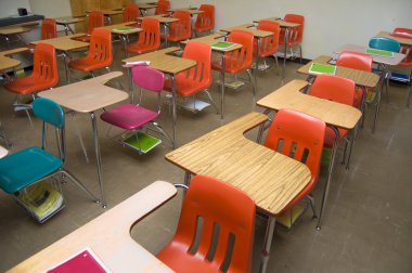 An empty class room with no students sitting in the desks. There are some notebooks laying around the room (none contain any logos.) clipart