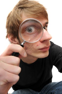 A young adult man looking down with a magnifying glass up to his eye, searching for just the right clue to crack the case of the mystery. clipart