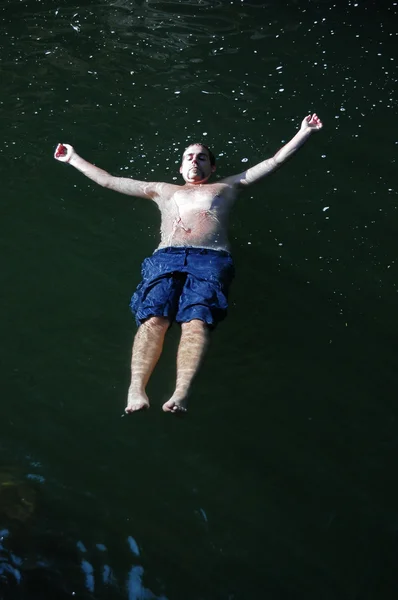 Homem flutuando na água nas costas — Fotografia de Stock