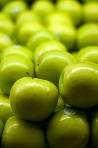 Manzanas verdes apiladas en el supermercado — Foto de Stock