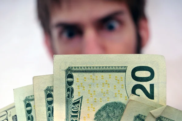 Mann starrt auf ein Bündel Bargeld — Stockfoto