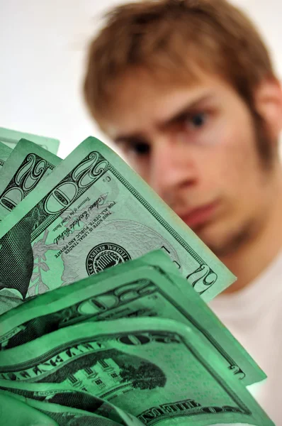 Homem olhando para um maço de dinheiro verde — Fotografia de Stock