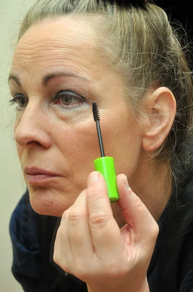 Woman putting on eyeliner — Stock Photo, Image