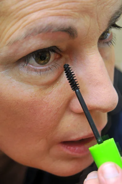 Woman putting on eyeliner — Stock Photo, Image