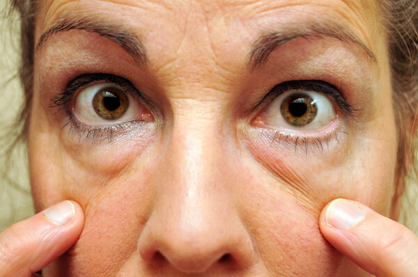 Middle Aged Woman Pointing at her eyes closeup. eyeliner is on.