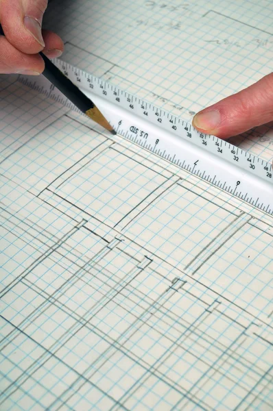 stock image House floor plan from architecture on grid paper with ruler and hands. This makes a great background.