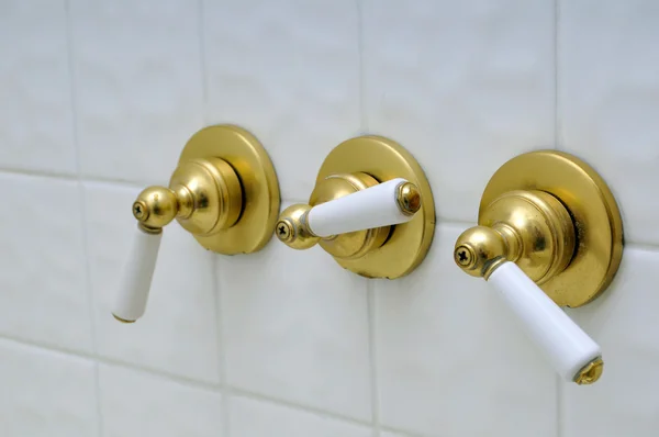Trois poignées de vanne de douche dorées — Photo
