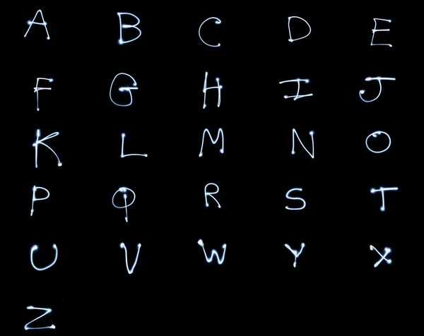 黑色背景上的发光字母表字母 长时间曝光光绘画风格 所有大写字母 — 图库照片