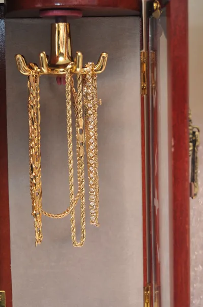黄金和白银手镯挂在一个小饰品柜 — 图库照片