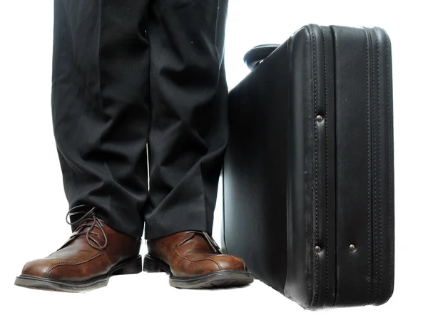 stock image A standard, default black briefcase with handle at top isolated on a pure white background resting on the floor next to a businessmans feet.