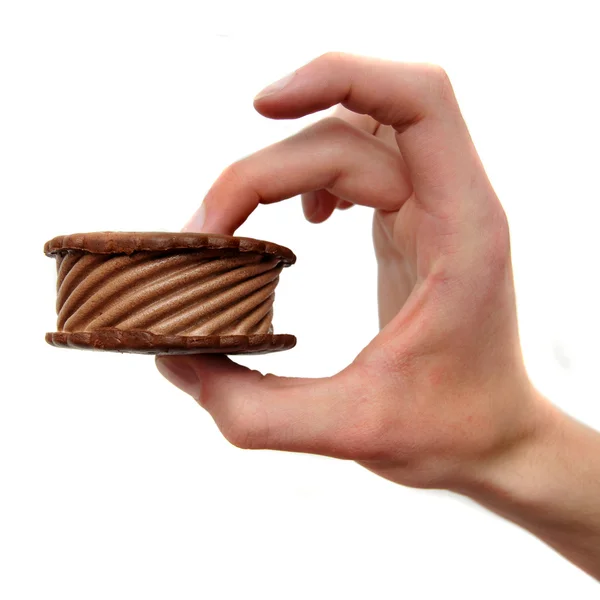 stock image Chocolate Ice Cream cookie Sandwich being held by a hand isolated on white background