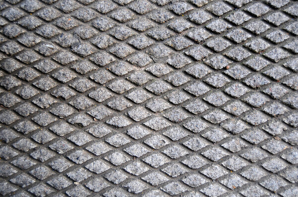 Cement grid indentation in asphalt. This makes a great grungy background texture.