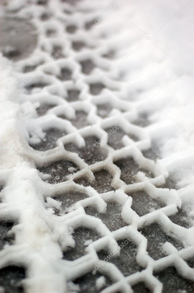 Black and white close up macro shot of tire tracks in slushy snow.