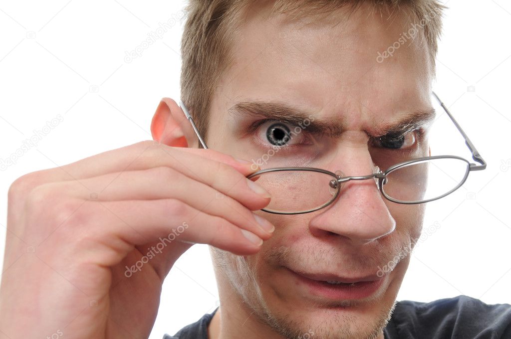 A curious white nerdy male takes down his glasses to closely inspect, examine and study his investigation.