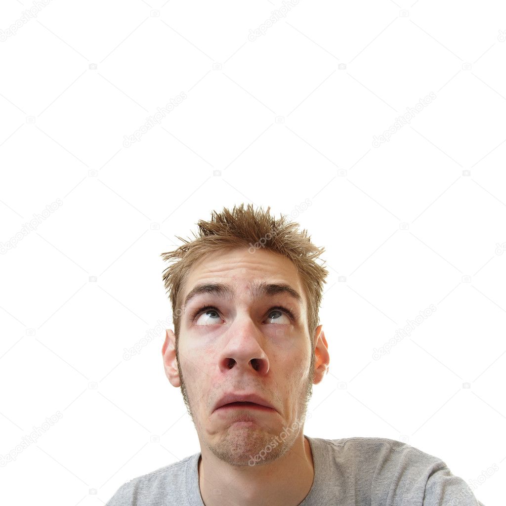 Young man looking upward overhead with a scared frown on his face isolated on white square background with room for your text