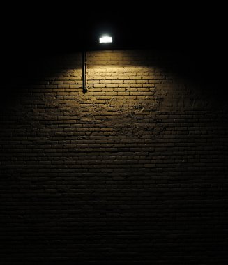 Old rough brick wall background texture with a spotlight shining on it clipart