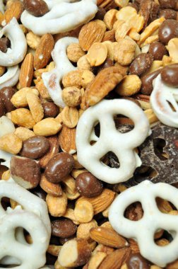 Trail mix contains white chocolate covered pretzels, chocolate covered pretzels, almonds, peanuts, pecans, walnuts, and chocolate covered raisin beans. clipart