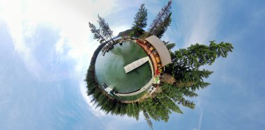 A 360x180 panoramic image projected to be in stereographic form. This is a pond with a dock, with trees and blue sky. clipart