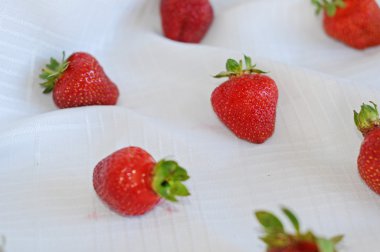 Beyaz bir bez üzerinde dağılmış strawberrys.