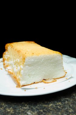 Angel food cake white short bread on a countertop isolated on black background above with room for you text. clipart