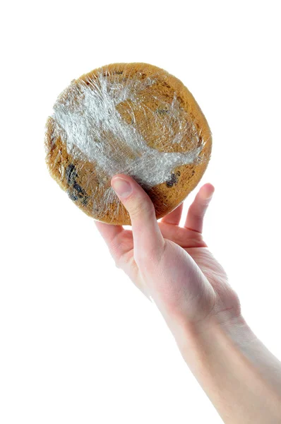 Mão segurando biscoito embrulhado plástico — Fotografia de Stock