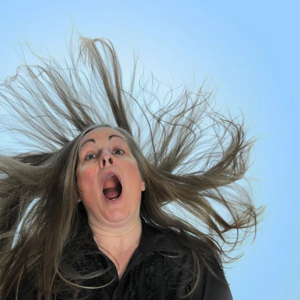 Kobieta Krzyczy Przed Niebieskim Tle Jej Włosów Wybuchowych Nią — Zdjęcie stockowe