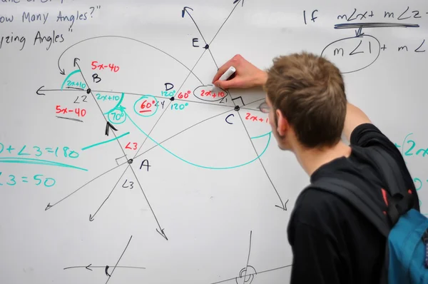 Estudante escrevendo matemática no quadro branco — Fotografia de Stock
