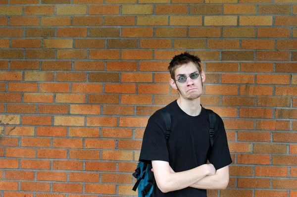 Студент прислонился к кирпичной стене — стоковое фото