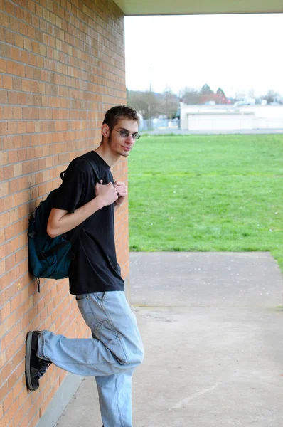 健康高个子白人男性白种人学生外站在一堵砖墙前 — 图库照片