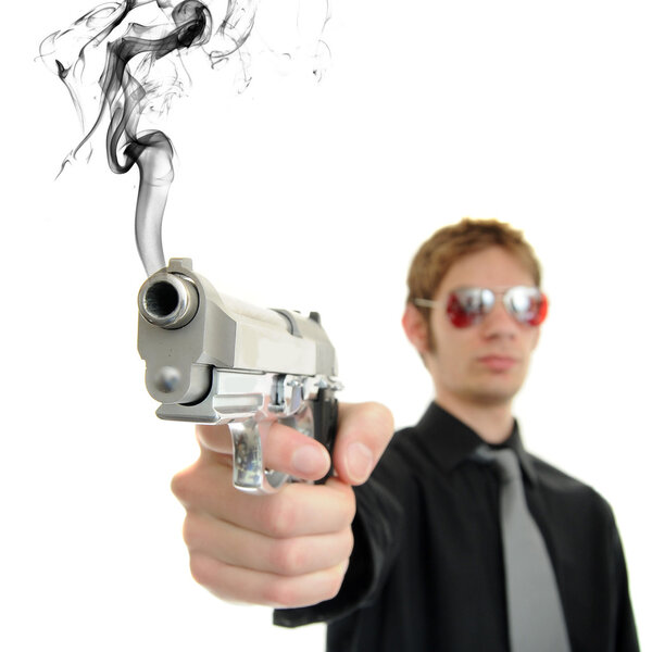 Young man holds his pistol out and shoots out smoke