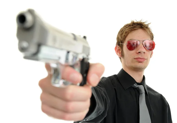 Молодой Человек Держит Пистолет Фокусом Лице Одет Солнечные Очки Изолирован — стоковое фото