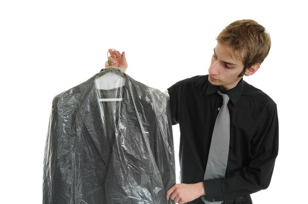 Young man holds newly dry cleaned business jacket coat