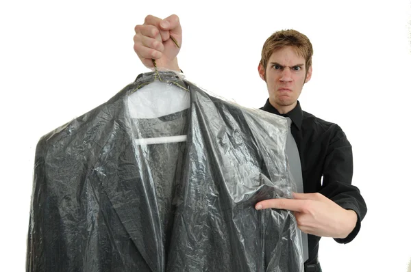 不满意的客户持有了一干已清理套西装 错过了一个点 — 图库照片