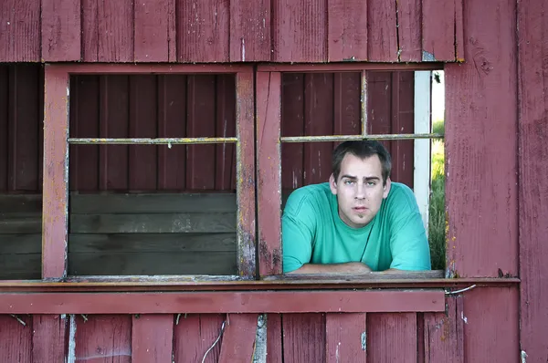 年轻成人白白种人农夫的男人看起来破窗外他旧谷仓内 — 图库照片