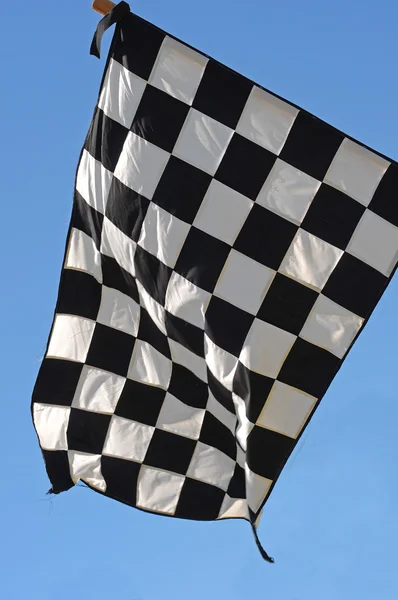 バック グラウンドで青い空と市松模様のレース旗 — ストック写真