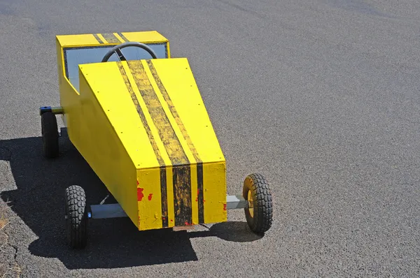 Ein Gelber Seifenkistenrennwagen Auf Einer Rennstrecke — Stockfoto