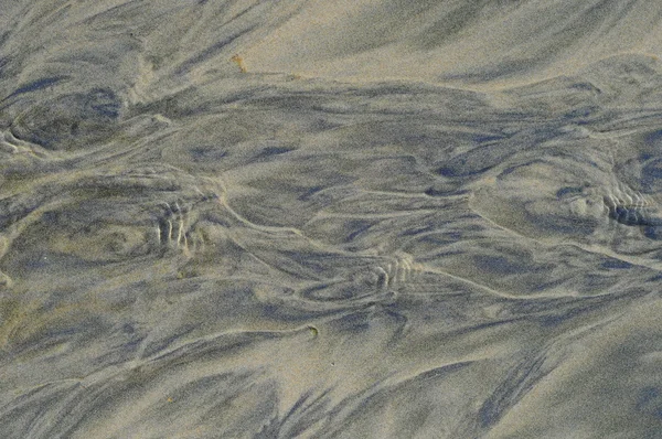 Вода течет по песку — стоковое фото